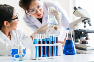 穿着实验服在实验室工作的科学家，他们在试管和科学仪器中检查生物化学样品。科学技术研究与开发的研究理念