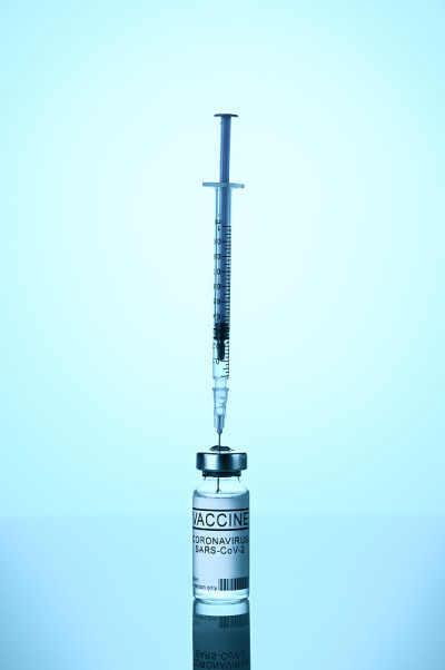 冠状病毒疫苗接种的概念。蓝色背景为COVID-19疫苗注射器。空间的文本