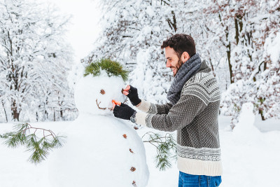一个年轻人在公园里堆雪人