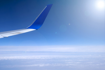 飞机机翼上的天空背景。飞机在云层上飞行。