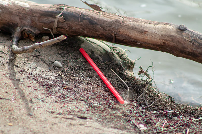 Pollution of plastic straws and fork left on beach