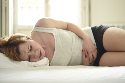年轻女子在床上肚子痛腹痛