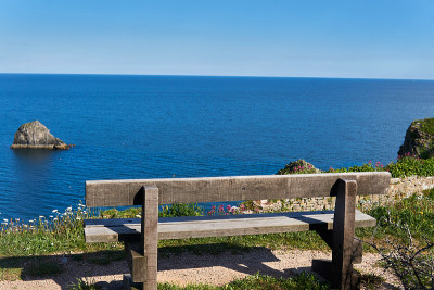 2021年6月04。Brixham,英国。在英国里维埃拉德文郡贝里黑德的海边，从木椅上看风景。蓝色的