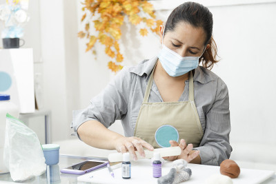 糕点师用翻糖装饰蛋糕-女人用面具烹饪-女人用染料在粘土上作画