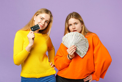 两个漂亮的金发双胞胎姐妹拿着信用卡