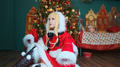 可爱的女孩cosplay圣诞Miku圣诞老人服装和礼物。新年的精灵。坐在地板上