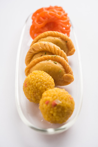 印度甜Jalebi/Imarti, Laddu和Gujiya一起在白色背景或与礼物。有选择性的重点