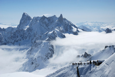 山脉在白云和滑雪者之间，阿尔卑斯山