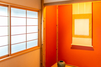 传统的日本房屋或旅馆，有关闭的推拉门、窗户和壁龛，有挂卷轴和红黄颜色