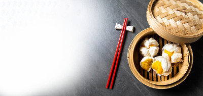 中国传统美食的概念。饺子点心在竹蒸笼内用文字抄写空间。亚洲食物背景