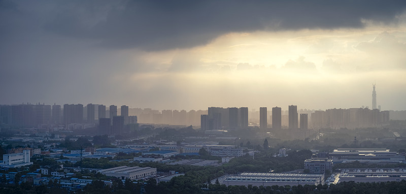 太阳在雨中穿过云层形成潮汐效应的城市
