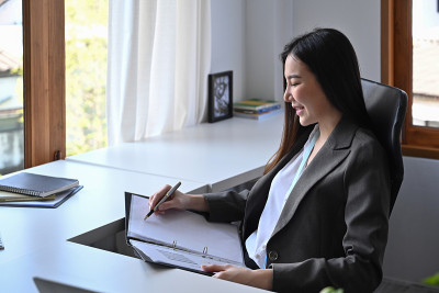 迷人的亚洲女商人在办公室分析财务信息。