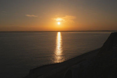 桑威奇湾海面上的日落。太阳在海面上反射出一束金色的光。