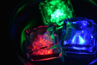 在一杯香槟中漂浮着绿、红、蓝三色的冰块，有趣又喜庆。