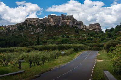 在一个阴天，一条通往法国普罗旺斯beaux de provence的道路，前方是橄榄树，这是普罗旺斯