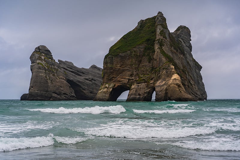 新西兰北岛纳尔逊，瓦拉里基海滩的波纹沙和岩层，拱门群岛，自然壁纸背景，风景摄影，惊人的石头形成