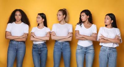 不同的女人看着站在黄色背景下的非洲女孩