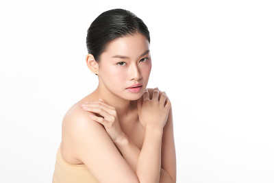 美丽年轻的亚洲女性干净清新的皮肤在白色背景，面部护理，面部护理，美容，美容和水疗，亚洲女性肖像。