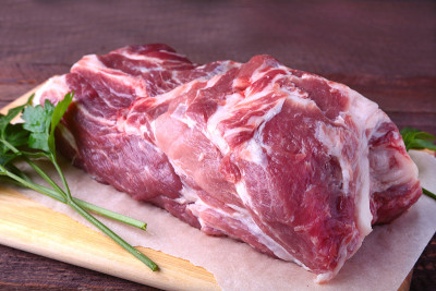 生猪颈剁肉和欧芹叶在石头背景上。准备做饭。