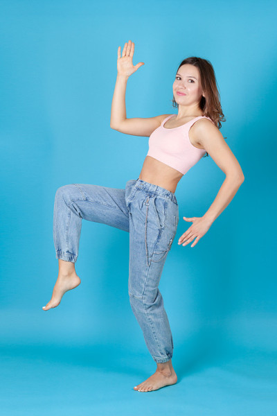 a full length young woman in jeans dances like Pin