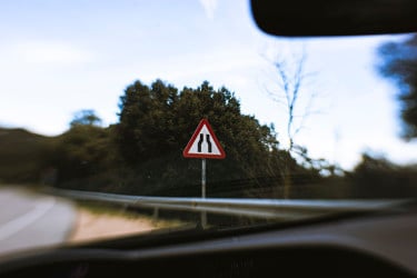 狭窄的街道危险标志在道路边缘从司机的视野内