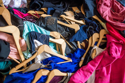 衣架上的衣服堆成一堆。一堆旧衣服。回收二手物品