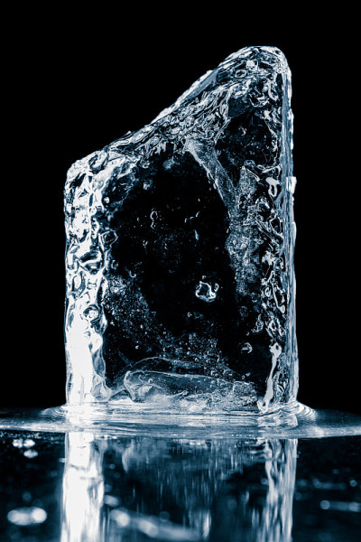 水晶清晰的自然冰块冷蓝色色调在黑色反射表面。