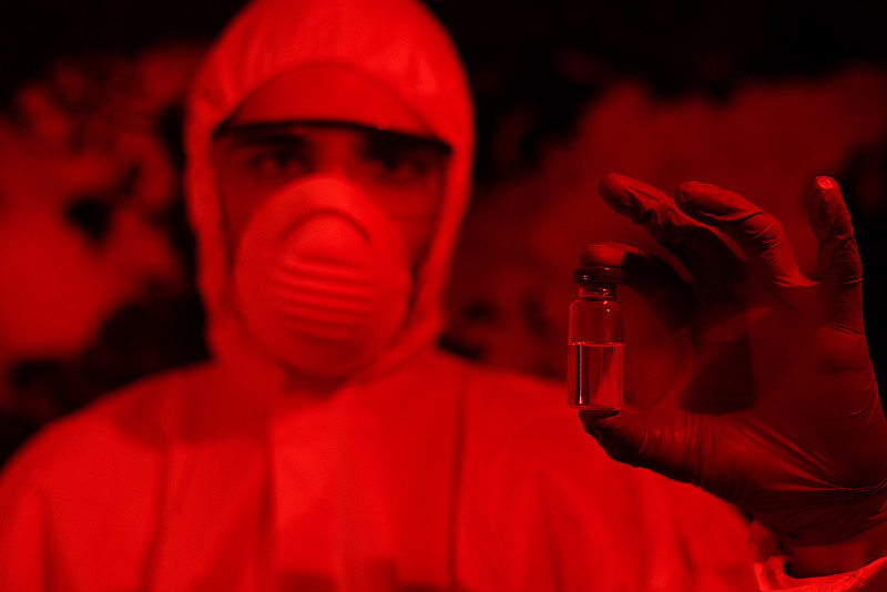 试管冠状病毒在实验室的病毒学家手中，以世界地图为背景