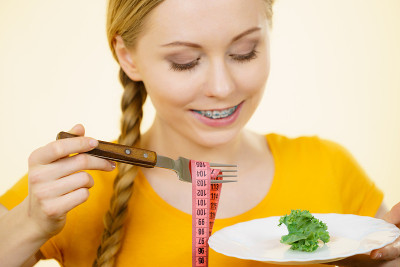 正在节食的女人拿着一盘生菜