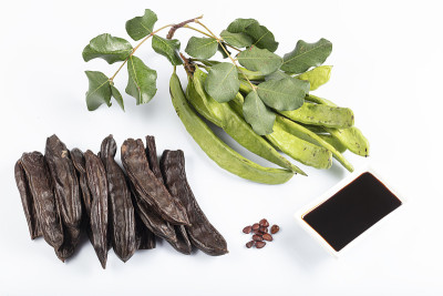 角豆的糖蜜和角豆荚(马具)在白色的背景。