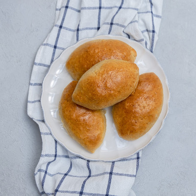 传统的俄罗斯包子(Piroshki)在白色盘子上的混凝土背景，俯视图