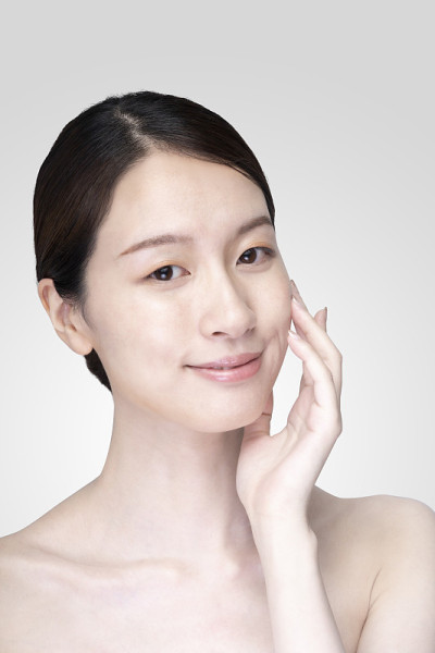 亚洲年轻女子触摸脸与放松的表情