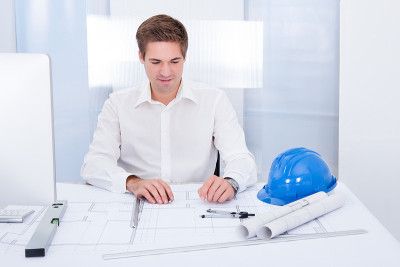 年轻建筑师在蓝图上绘制计划