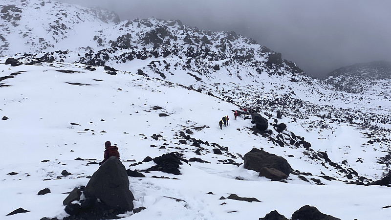 一群登山者从雪山上下来。在克柳切夫斯科伊火山公园徒步旅行。