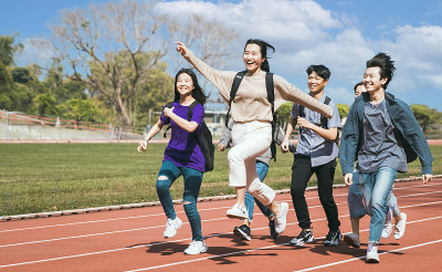 快乐的年轻组学生跑过田野