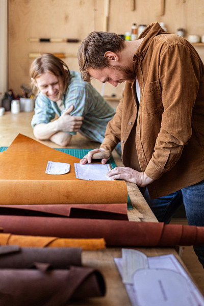在皮革车间工作的工匠在解开天然材料的包裹。Leatherwork
