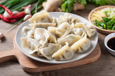 快来看看新鲜的水饺。中国食物在乡村古老的木制背景。