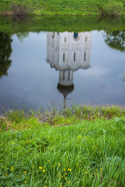 白色教堂与蓝色穹顶的倒影和风景如画的云彩，博格鲁波沃，俄罗斯