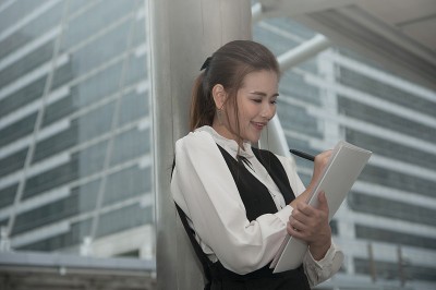 亚洲漂亮的女人在黑衣书写文件。