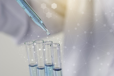 生物化学实验室研究，科学家或医务人员在实验室工作的玻璃设备上，穿着实验室大褂，拿着带有彩色液体的使用