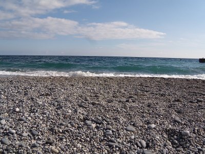 海边的波浪和浪花。海滩上的石头和贝壳。