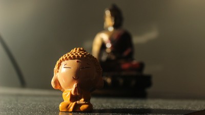 橙色小佛像，后面有一个更大的红色佛像(模糊)