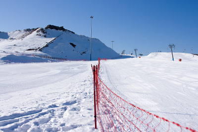 日落时空旷的滑雪场。从积雪覆盖的斜坡上下来。