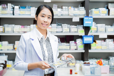 肖像亚洲女药剂师在班级配药药剂师前