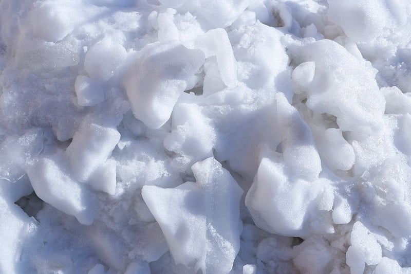 白雪的背景。春天雪融化。