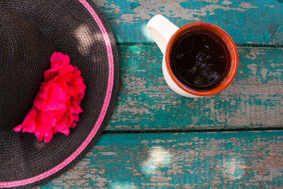 优雅的夏日帽子和一杯茶