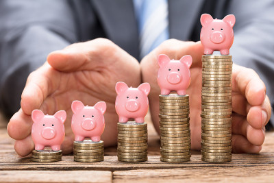商人保护堆叠硬币上的Piggybank