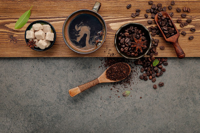 烘焙咖啡豆与咖啡杯设置在深色的石头背景。