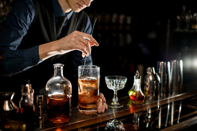 酒保用勺子轻轻搅拌冷鸡尾酒