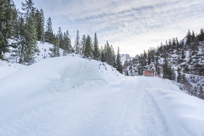冰雪覆盖的山路上有冬天的雪堆和白雪覆盖的森林